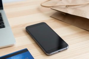 Смартфон, ноутбук и банковская карта на столе для онлайн-покупок